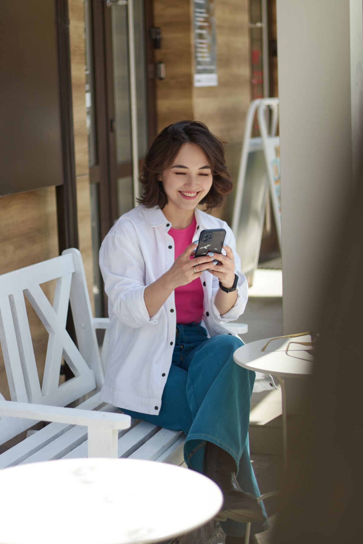 カフェでスマホを見て微笑む女性